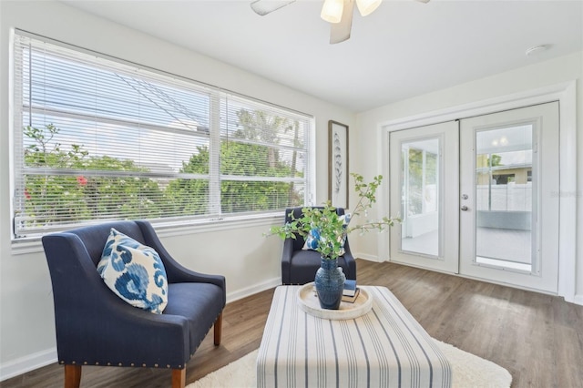 living area featuring french doors, baseboards, a ceiling fan, and wood finished floors