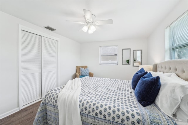 bedroom featuring visible vents, a closet, baseboards, ceiling fan, and dark wood-type flooring