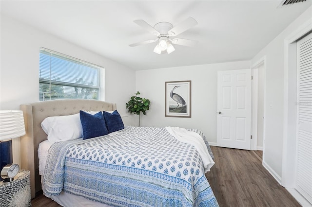 bedroom with baseboards, a ceiling fan, a closet, and wood finished floors