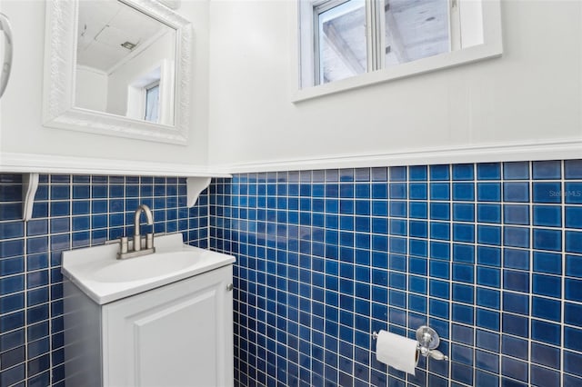 bathroom featuring wainscoting, tile walls, and vanity