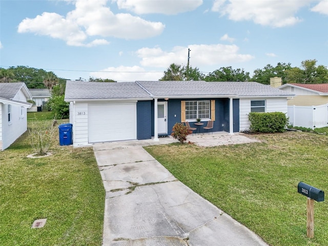 ranch-style house featuring fence, an attached garage, concrete driveway, and a front lawn