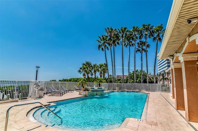 view of swimming pool featuring fence, a patio area, and a pool with connected hot tub
