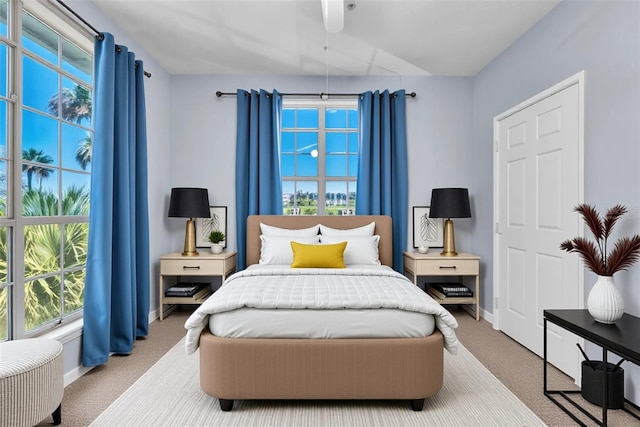 bedroom with baseboards, multiple windows, and carpet