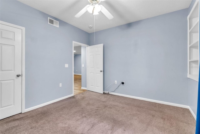 unfurnished bedroom featuring a ceiling fan, visible vents, carpet, and baseboards