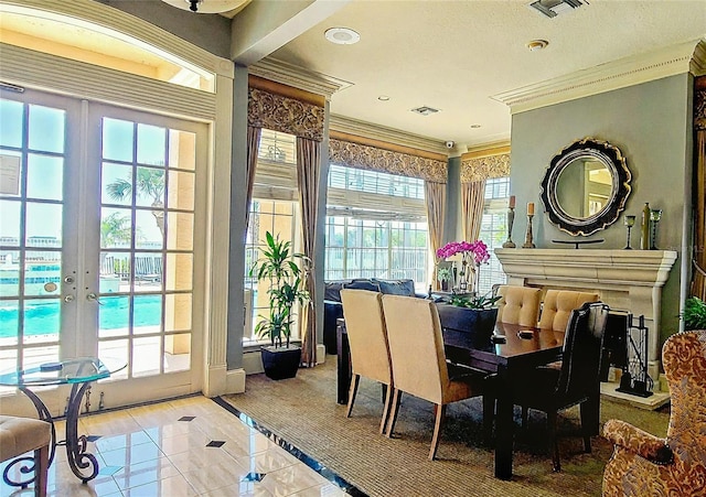 dining area with crown molding, light tile patterned flooring, visible vents, and french doors