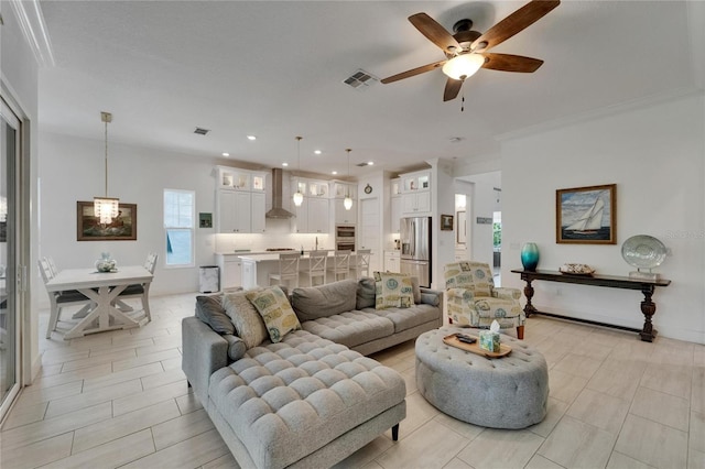 living area featuring ceiling fan, ornamental molding, recessed lighting, and visible vents