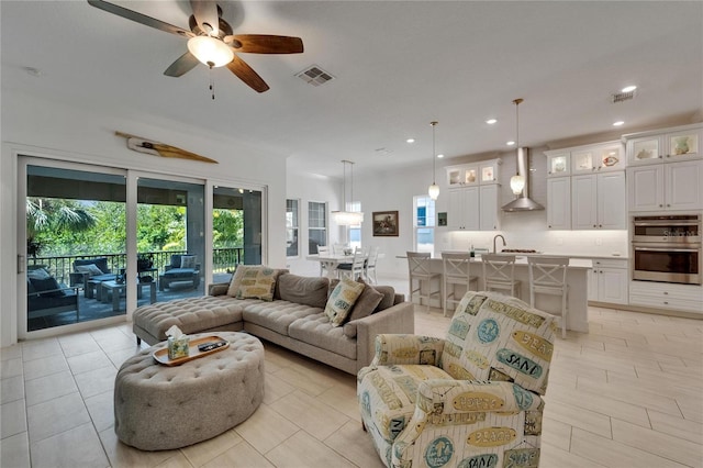living area with visible vents, a ceiling fan, light tile patterned flooring, and recessed lighting