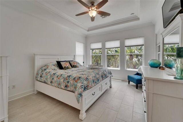 bedroom with ceiling fan, visible vents, light tile patterned floors, a raised ceiling, and ornamental molding