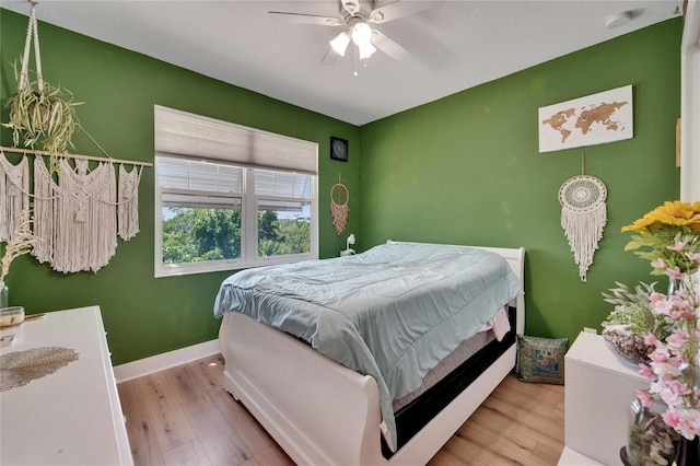 bedroom featuring baseboards, a ceiling fan, and wood finished floors