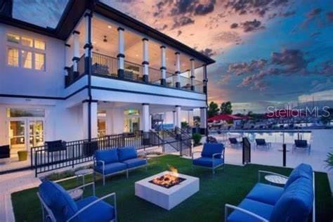rear view of property with a patio, an outdoor living space with a fire pit, and a balcony