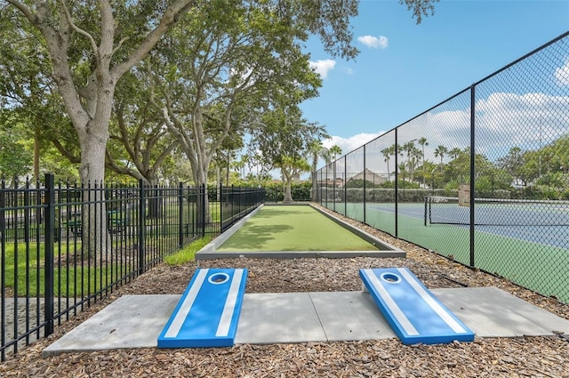 surrounding community featuring a tennis court and fence