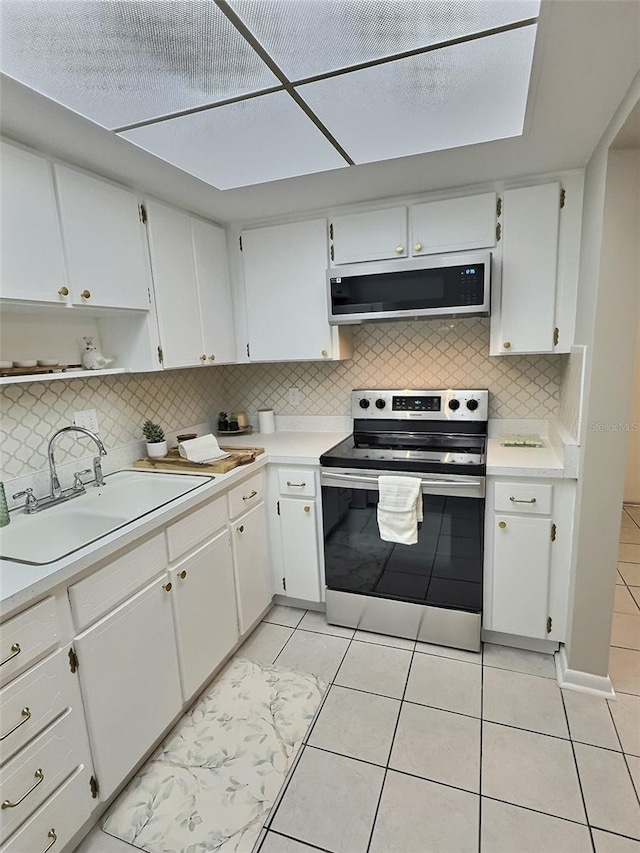 1001 77th Ave N Unit 206, Saint Petersburg, FL 33702 - kitchen with light tile patterned floors, stainless steel appliances, decorative backsplash, and a sink