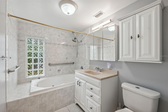 bathroom with toilet, vanity, tile patterned floors, and tiled shower / bath combo