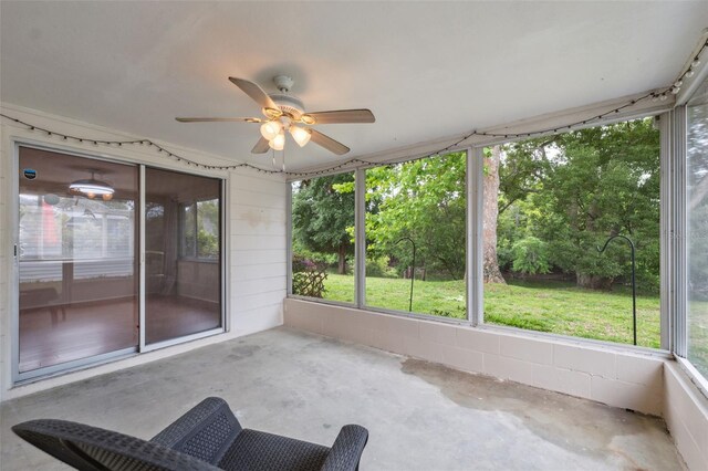 unfurnished sunroom featuring ceiling fan and healthy amount of natural light