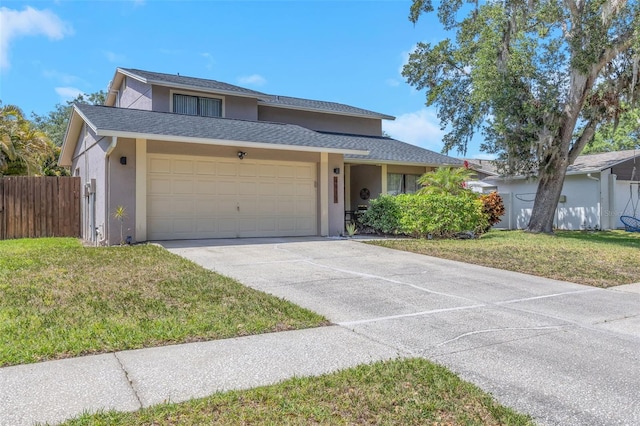 traditional home featuring a front yard, a garage, stucco siding, and fence