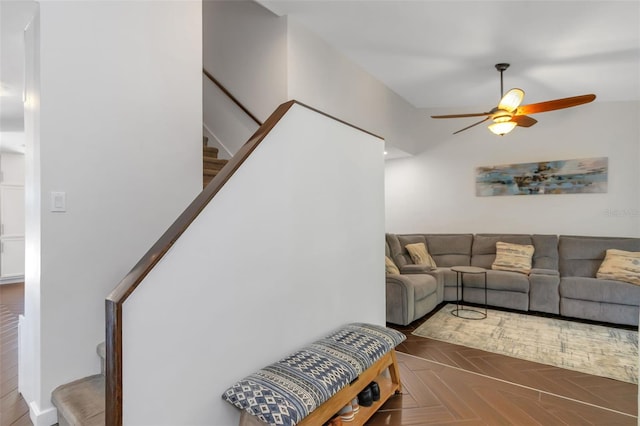 living room featuring a ceiling fan and stairs
