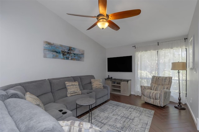 living room with a ceiling fan, vaulted ceiling, and baseboards