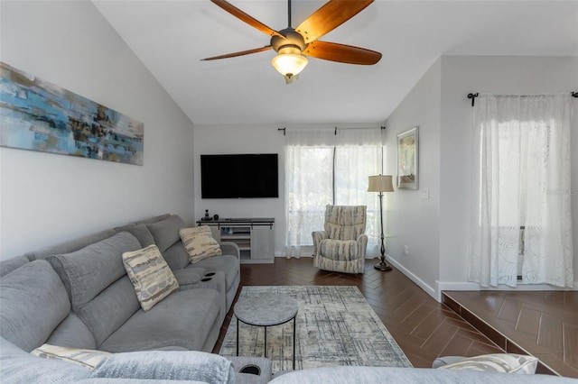 living room featuring lofted ceiling, a ceiling fan, and baseboards
