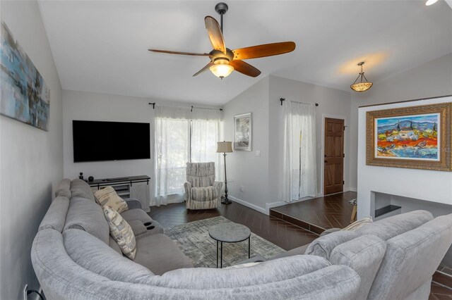 living area with baseboards, wood finished floors, ceiling fan, and lofted ceiling