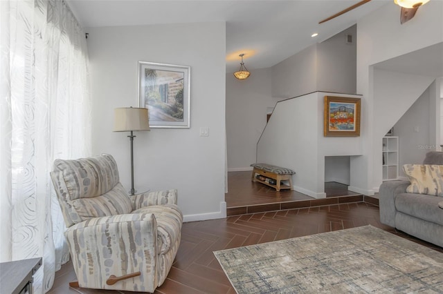 living room with a ceiling fan, a healthy amount of sunlight, and baseboards