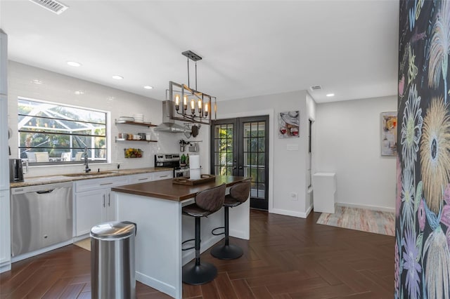 kitchen featuring a sink, a center island, extractor fan, appliances with stainless steel finishes, and plenty of natural light