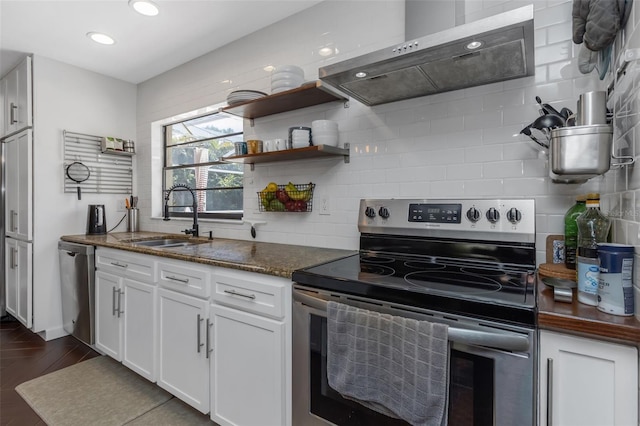 kitchen featuring white cabinetry, tasteful backsplash, a sink, appliances with stainless steel finishes, and exhaust hood