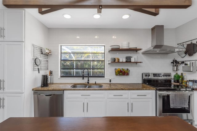 kitchen with a sink, white cabinetry, stainless steel appliances, and wall chimney exhaust hood
