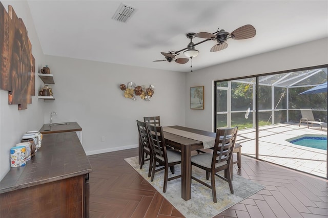 dining space with baseboards, visible vents, a ceiling fan, and a sunroom