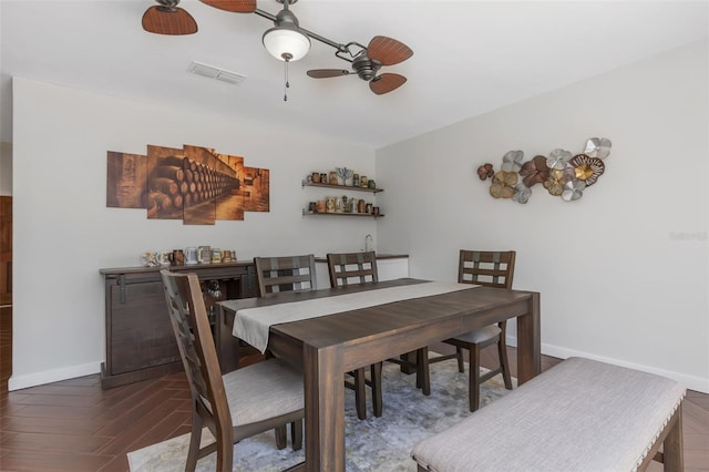 dining room with a ceiling fan, visible vents, wood finished floors, and baseboards