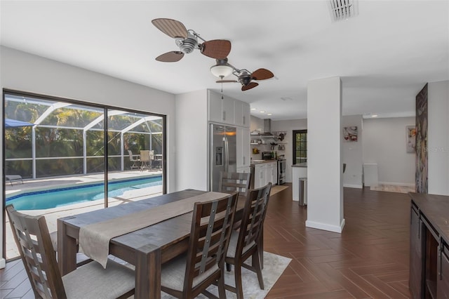 dining space featuring visible vents, a ceiling fan, a sunroom, and baseboards