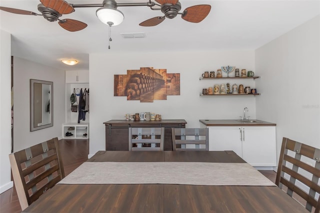 dining room featuring visible vents, a ceiling fan, and dark wood-style flooring