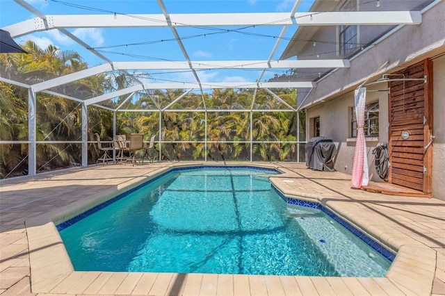 outdoor pool with a patio and area for grilling