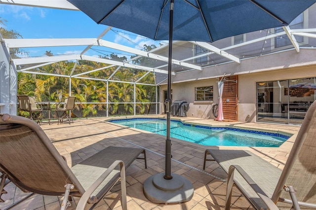 pool with a patio area and glass enclosure