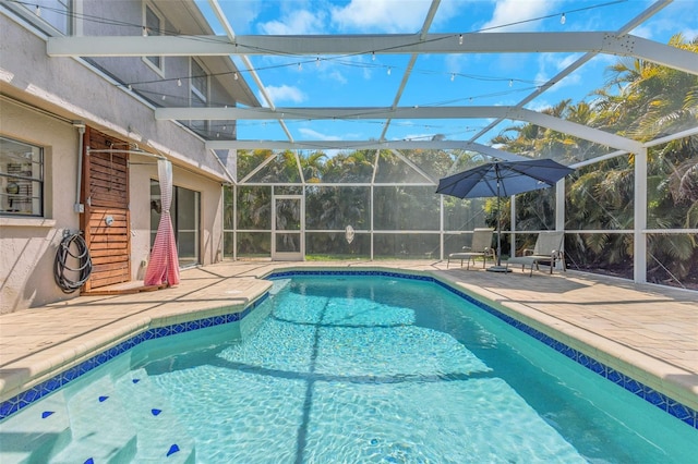 outdoor pool featuring glass enclosure and a patio area
