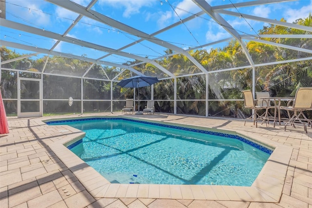 outdoor pool featuring glass enclosure and a patio area