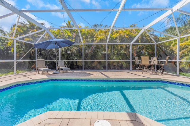outdoor pool with a patio and glass enclosure