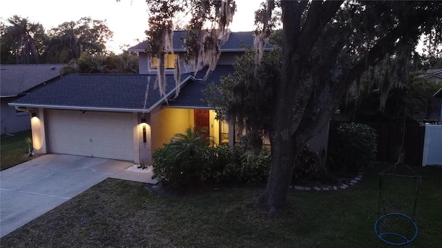 view of front of property featuring a front lawn, stucco siding, driveway, roof with shingles, and an attached garage