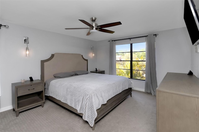 bedroom with baseboards, a ceiling fan, and light carpet