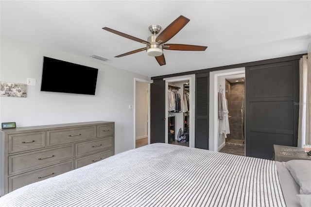 bedroom featuring ceiling fan, visible vents, a closet, a spacious closet, and ensuite bath