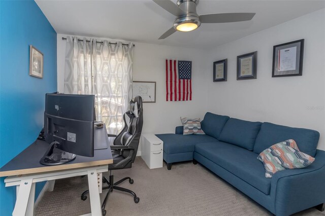 carpeted office with a ceiling fan