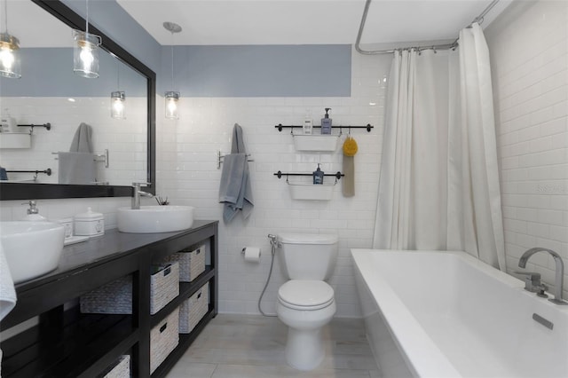 bathroom featuring tile walls, shower / tub combo, and a sink