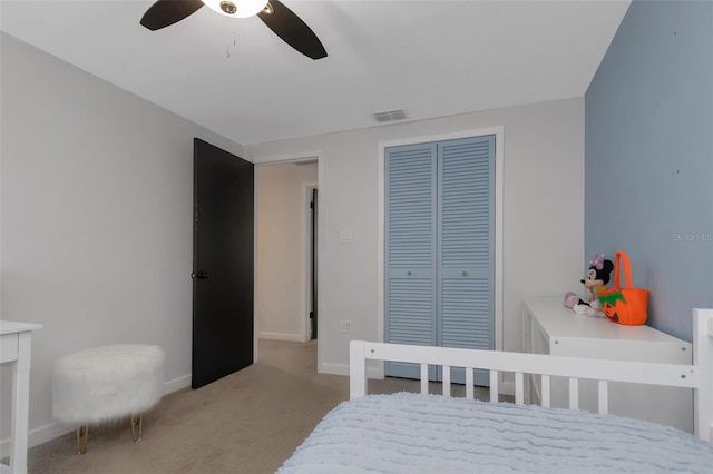 bedroom featuring a closet, ceiling fan, visible vents, baseboards, and light colored carpet