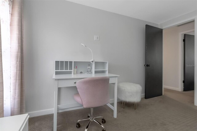 carpeted office featuring baseboards