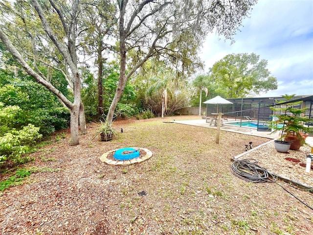 view of yard with a lanai, a fenced in pool, and a patio area