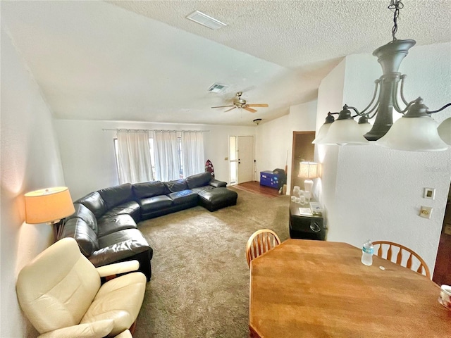 living area featuring a ceiling fan, carpet flooring, vaulted ceiling, and visible vents