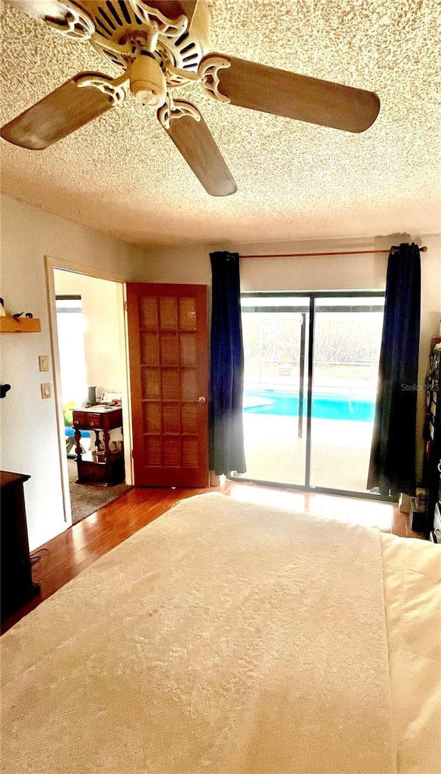 unfurnished bedroom featuring a textured ceiling, a ceiling fan, and access to outside