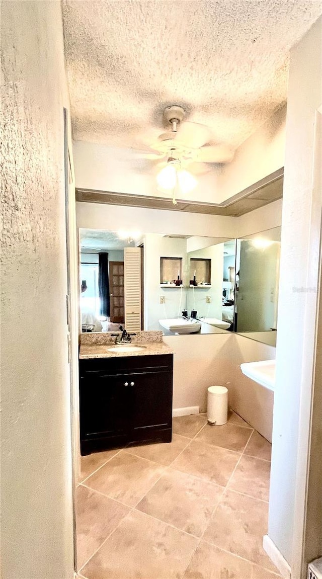 bathroom featuring tile patterned flooring, a textured ceiling, a ceiling fan, and ensuite bathroom