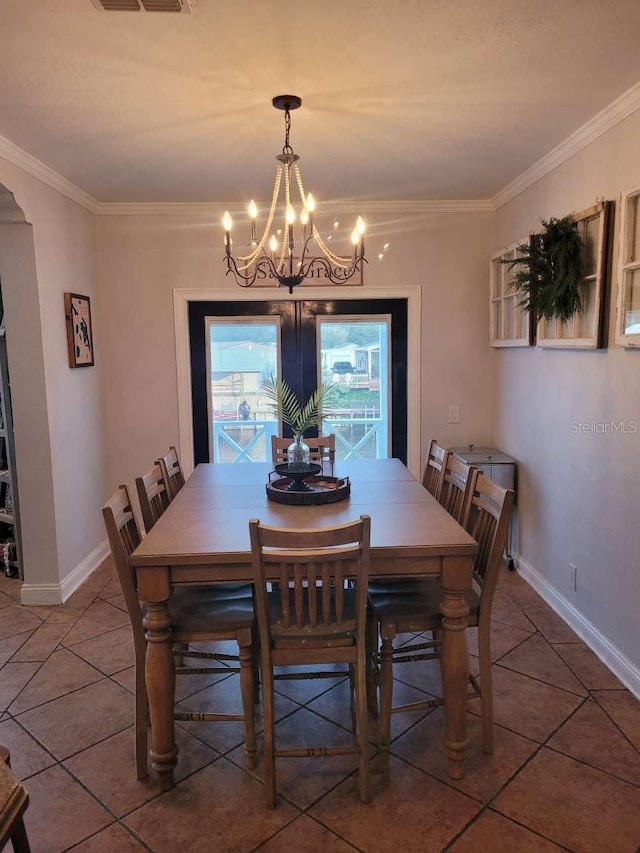 tiled dining room featuring visible vents, ornamental molding, baseboards, and a notable chandelier