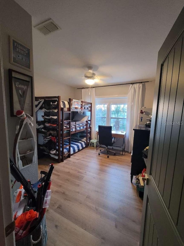 bedroom with ceiling fan, visible vents, and light wood-style flooring