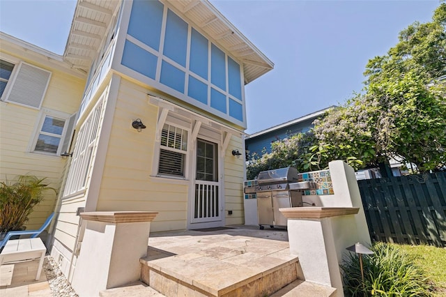 property entrance featuring a patio area and fence